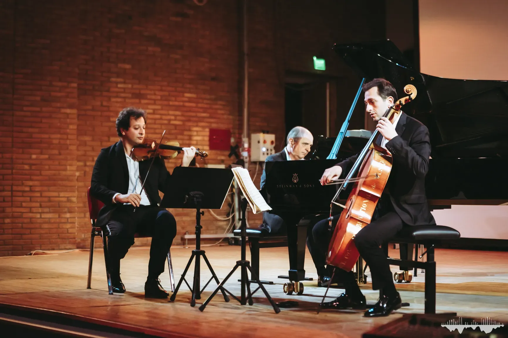 A piano trio with violin and cello on stage, at a Transylvania State Philharmonic concert
