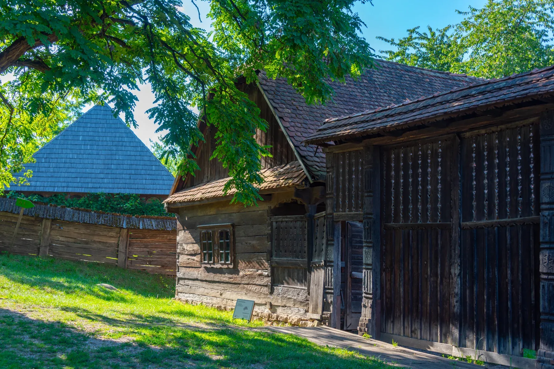 A timber homestead in the park, with plank gates and fence