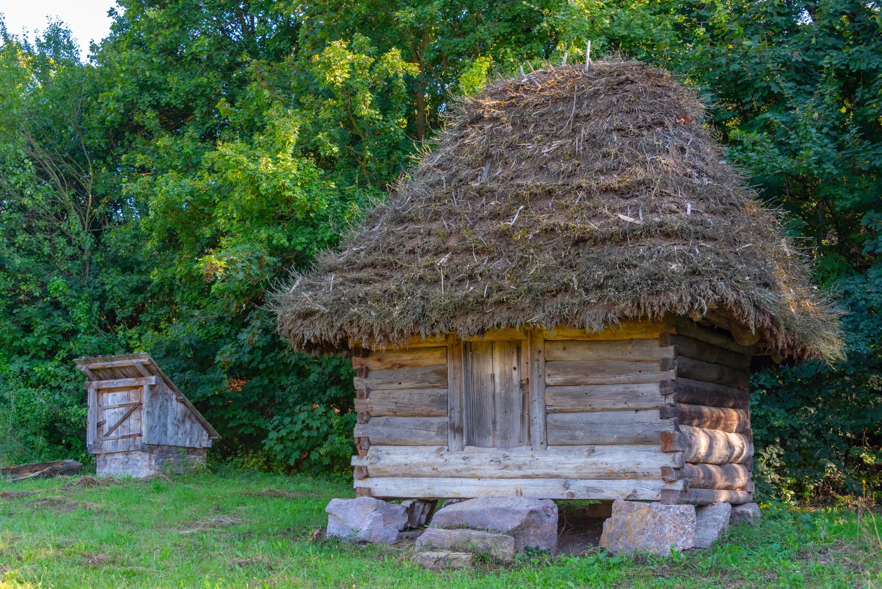 A small thatched granary set on stones