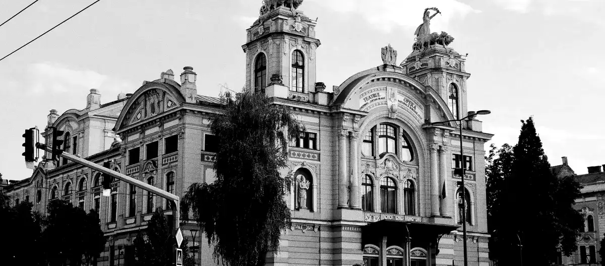 The building of the Romanian National Opera and the “Lucian Blaga” National Theatre at sunset. Both names can be read on the facade.