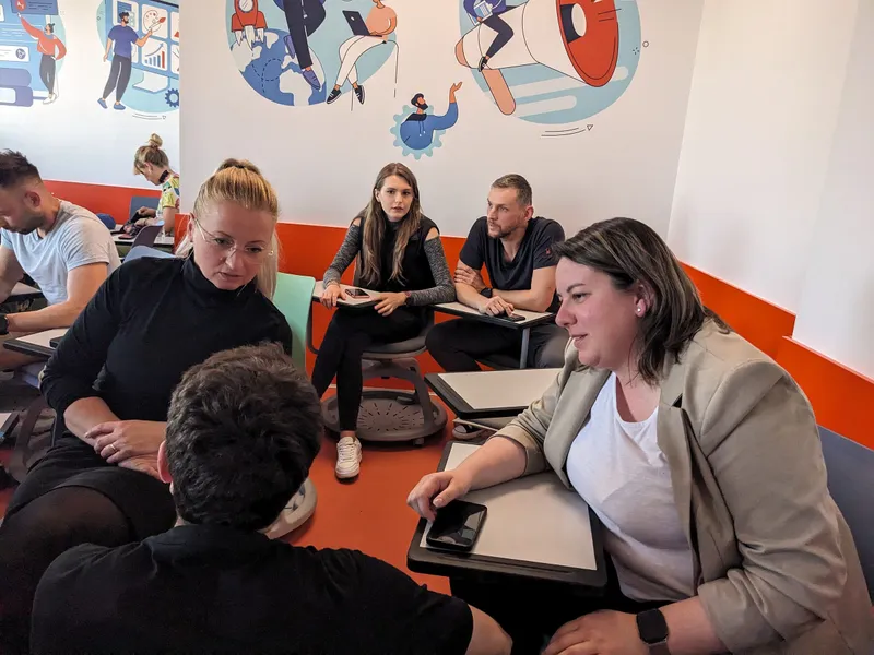 A small group in conversation around a table during the feedback session